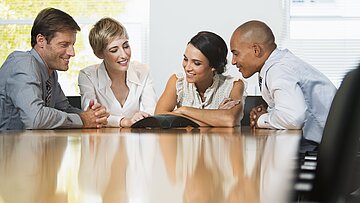 Foto: Vier Personen am Konferenztisch