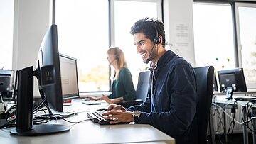 Foto: Mann mit Headset im Büro